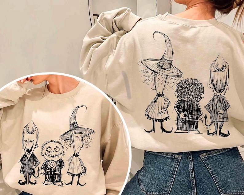 Puede incluir: Sudadera color crema con un boceto en blanco y negro de tres personajes de Pesadilla antes de Navidad. El dise&ntilde;o est&aacute; en la parte delantera y trasera de la sudadera. Los personajes incluyen una bruja, un ni&ntilde;o con una piruleta y un diablo.