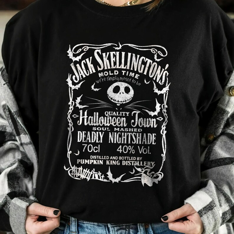 May include: Black crew neck t-shirt featuring a white graphic design. The design includes the text "Jack Skellington's" and "Halloween Town", along with other text and imagery. The shirt also has the text "Deadly Nightshade" and "70cl".