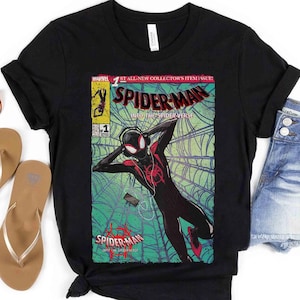 Puede incluir: Camiseta negra con un dise&ntilde;o de portada de c&oacute;mic. El dise&ntilde;o presenta el texto "SPIDER-MAN" y una ilustraci&oacute;n de un superh&eacute;roe. Las palabras "INTO THE SPIDER-VERSE" tambi&eacute;n son visibles.