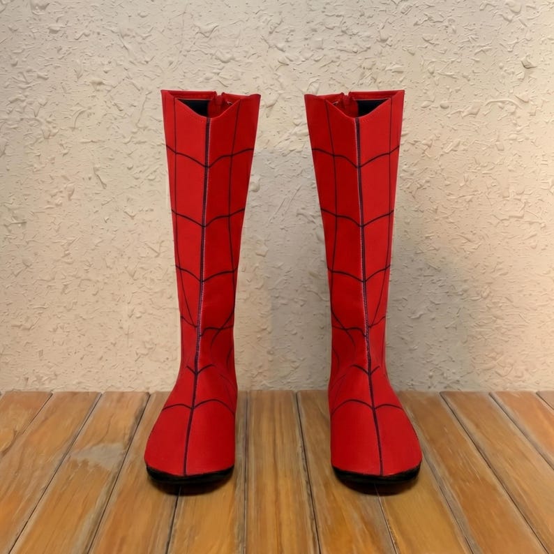Puede incluir: Un par de botas hasta la rodilla de color rojo vibrante, con un patr&oacute;n de telara&ntilde;a negro prominente impreso en toda la superficie. Las botas tienen un dise&ntilde;o de ca&ntilde;a alta y estructurada con punta redondeada y suela plana.