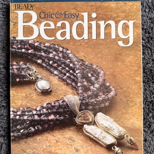 Könnte beinhalten: Ein Buchcover mit dem Titel "100 Fast and Fun Fashion Jewelry Projects" und dem Titel "Chic & Easy Beading". Das Cover zeigt geschmückten Schmuck in Lila- und Silbertönen, darunter eine Halskette und Ohrringe. Der Name des Autors, Alice Korach, ist ebenfalls sichtbar.