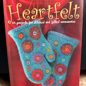 May include: The book 'Heartfelt' with the subtitle '25 projects for stitched and felted accessories' features a pair of turquoise mittens decorated with colourful embroidery and buttons. The background is a deep red.