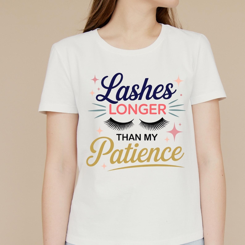 May include: White t-shirt with the text "Lashes Longer Than My Patience" in navy blue, gold, and pink. The design includes stylized eyelashes and stars. The shirt is a crew neck.
