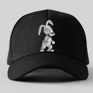 K&ouml;nnte beinhalten: Schwarze Baseballkappe mit einem Cartoon-Kaninchen-Design. Das Kaninchen ist grau mit blauen Augen und langen Ohren. Die Kappe hat einen gebogenen Schirm und einen Knopf oben.