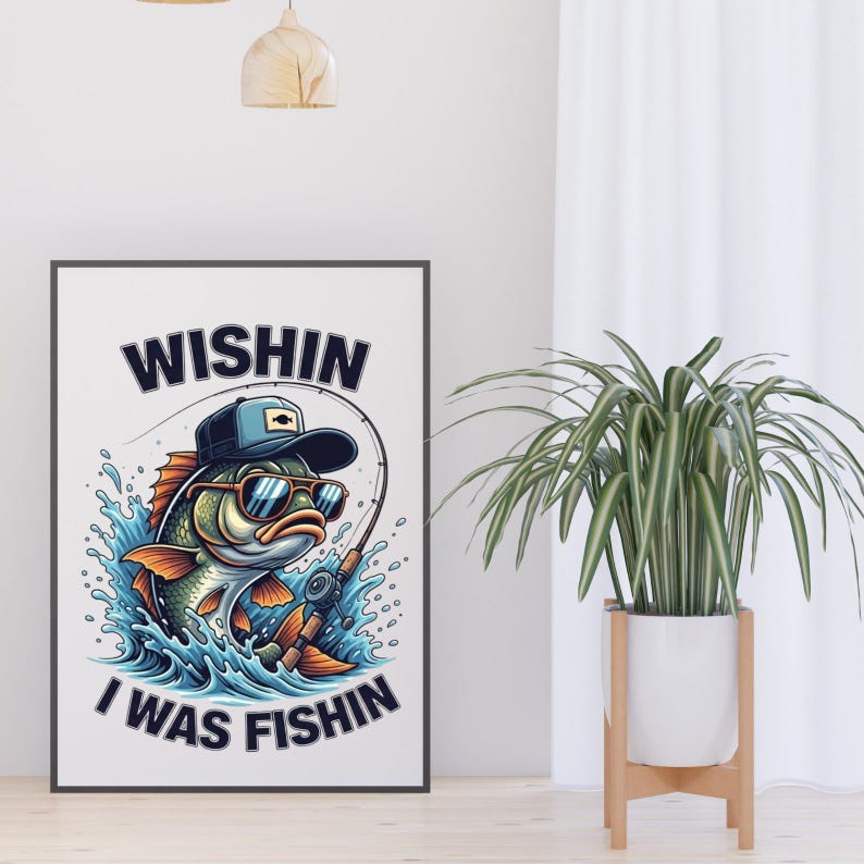 K&ouml;nnte beinhalten: Ein gerahmter Kunstdruck mit einem Cartoon-Fisch, der eine Sonnenbrille und eine Kappe tr&auml;gt und angelt. Das Kunstwerk enth&auml;lt den Text "Wishin I Was Fishin" in Marineblau. Der Fisch ist in Gr&uuml;n-, Orange- und Blaut&ouml;nen dargestellt.