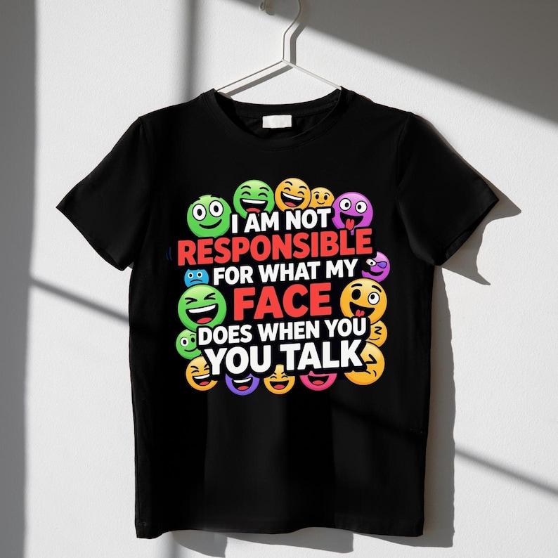 May include: Black t-shirt with a colorful emoji design. The shirt features various emoji faces and the text "I am not responsible for what my face does when you talk."