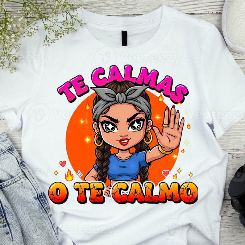 May include: White t-shirt with a cartoon graphic of a woman with a gray headband and braids, set against an orange circle. The text "TE CALMAS O TE CALMO" is in pink and orange. The woman is wearing a blue top.