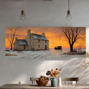 May include: Panoramic wall art print of a winter landscape featuring a stone house, bare trees, and a horse-drawn carriage against a vibrant orange and yellow sunset. The scene is covered in snow, creating a serene and rustic ambiance.