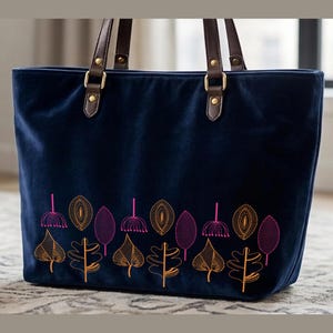 Puede incluir: Bolso tote de terciopelo azul marino con asas de cuero marrón y herrajes dorados. El bolso presenta un diseño floral bordado en tonos naranja y rosa. El bolso tote está diseñado para el uso diario.