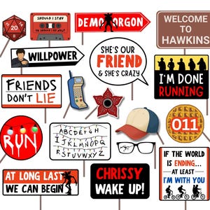 Könnte beinhalten: Eine Sammlung von Schildern und Requisiten mit Text und Illustrationen, darunter ein Demogorgon-Pfeil, eine Kassette, eine Baseballkappe und eine Waffel mit "011". Die Schilder zeigen Sätze wie "Friends Don't Lie" und "Chrissy Wake Up!"