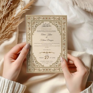 May include: A rectangular wedding invitation card with a cream-colored background and an ornate, intricate floral border in shades of gold, brown, and red. The text includes the names Adam Khan and Fatima Bunyas, the date June 27, and Diyanet Event Hall.