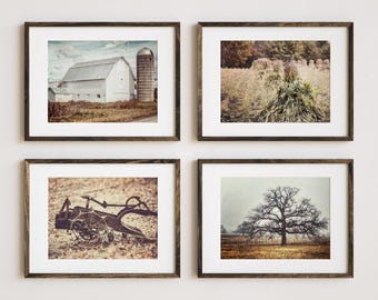 May include: Four framed art prints featuring rural scenes. The top left print shows a white barn and silo. The top right print depicts tall grasses. The bottom left print shows an old farm implement. The bottom right print shows a large tree.