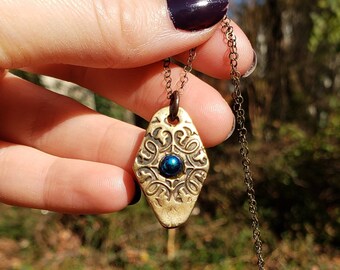 Geometric handmade bronze diamond pendant with blue stone