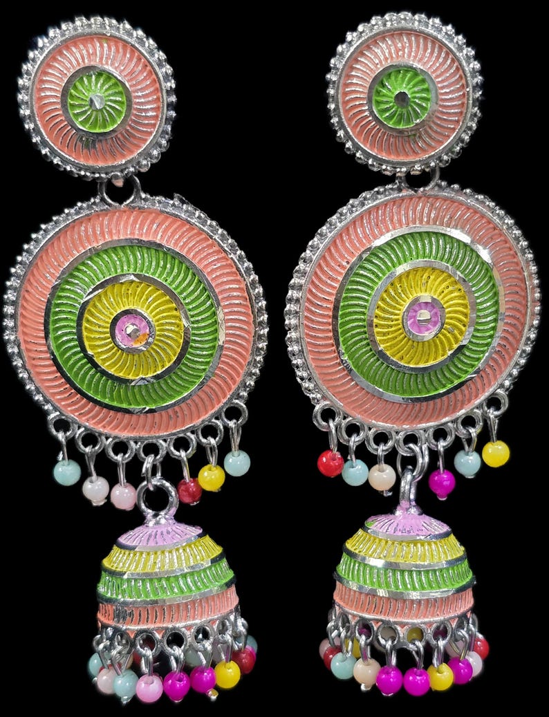 K&ouml;nnte beinhalten: Ein Paar bunte H&auml;ngeohrringe mit kreisf&ouml;rmigem Design. Die Ohrringe haben konzentrische Kreise in Rosa, Gr&uuml;n und Gelb mit einem kleinen glockenf&ouml;rmigen Anh&auml;nger am unteren Ende. Kleine, farbige Perlen h&auml;ngen von der Unterseite der Ohrringe.