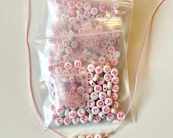 81 cuentas rosas con letras hebreas de 7 mm, además de corazones, pequeños separadores y detalles bañados en plata.