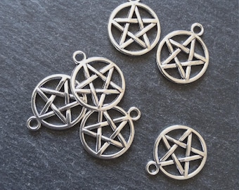 May include: Silver-colored pentagram charms. Each charm features a five-pointed star within a circular frame, with a small loop at the top for attachment. The charms are displayed on a dark gray, textured surface.