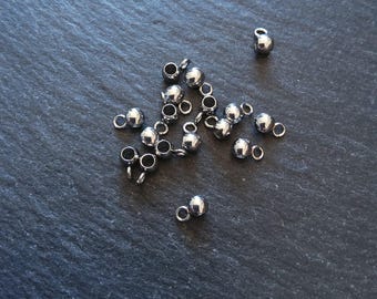 May include: A collection of small, shiny, silver-colored metal beads with a loop attached. The beads are spherical and scattered across a dark, textured surface. These jewelry-making components are ideal for crafting necklaces, bracelets, and earrings.