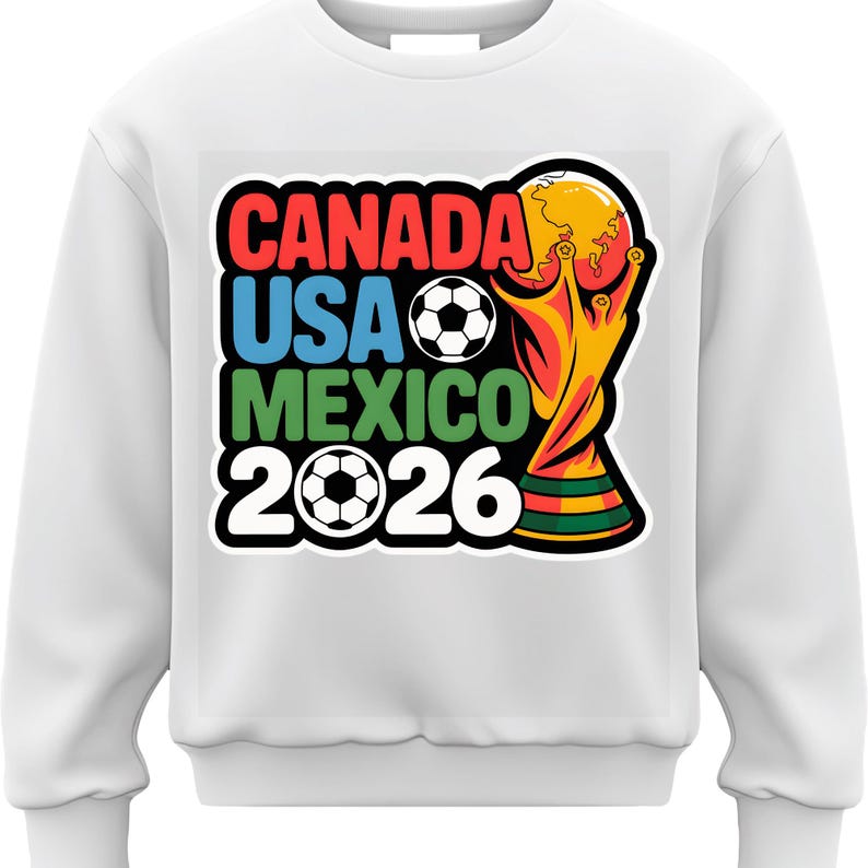 以下が含まれることがあります： 2026 FIFAワールドカップのグラフィックがプリントされた白いスウェットシャツ。「CANADA USA MEXICO 2026」の文字が赤、青、緑、白でデザインされています。サッカーボールとトロフィーも含まれています。