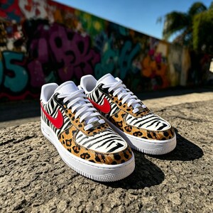 May include: Customised trainers with a distinctive animal print design. The shoes have a white sole, white laces, and a red swoosh. The upper part of the shoe features a combination of zebra and leopard print patterns.