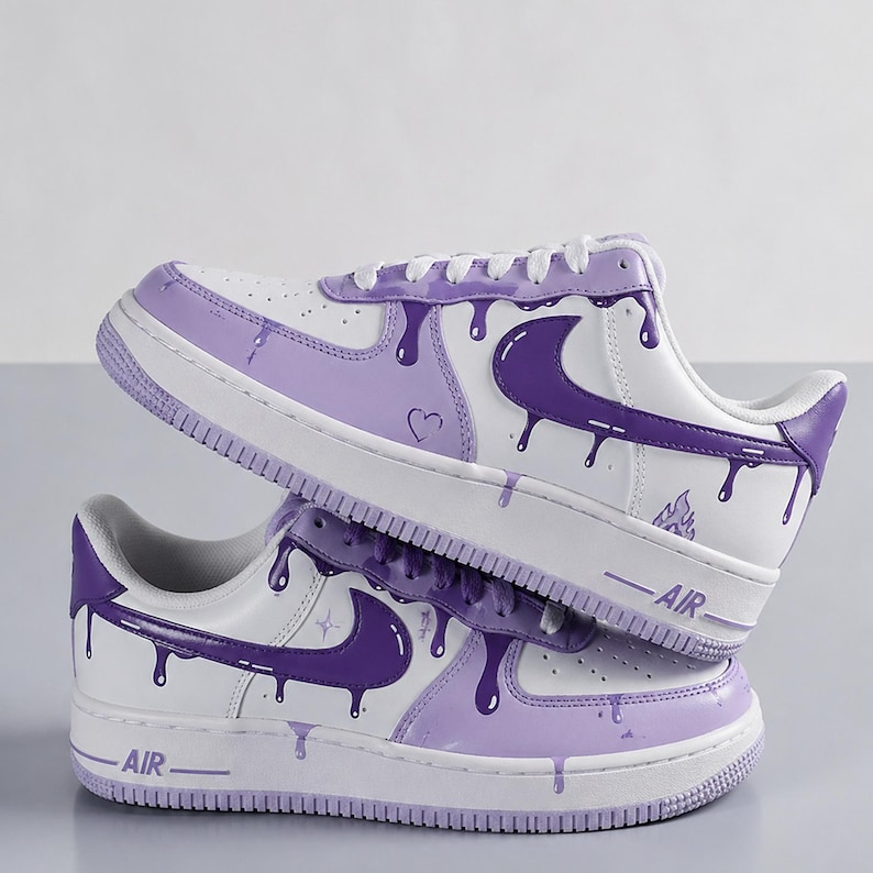 May include: White and purple custom sneakers with a dripping paint design. The sneakers feature a white base with purple accents, including the Nike swoosh, laces, and a dripping paint effect. The word "AIR" is visible on the side of the sole.