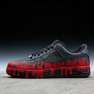 May include: Black and red custom Air Force 1 sneakers. The black leather upper features a black Nike swoosh and laces. The red base has black dripping paint details. The sole is black with "AIR" branding.