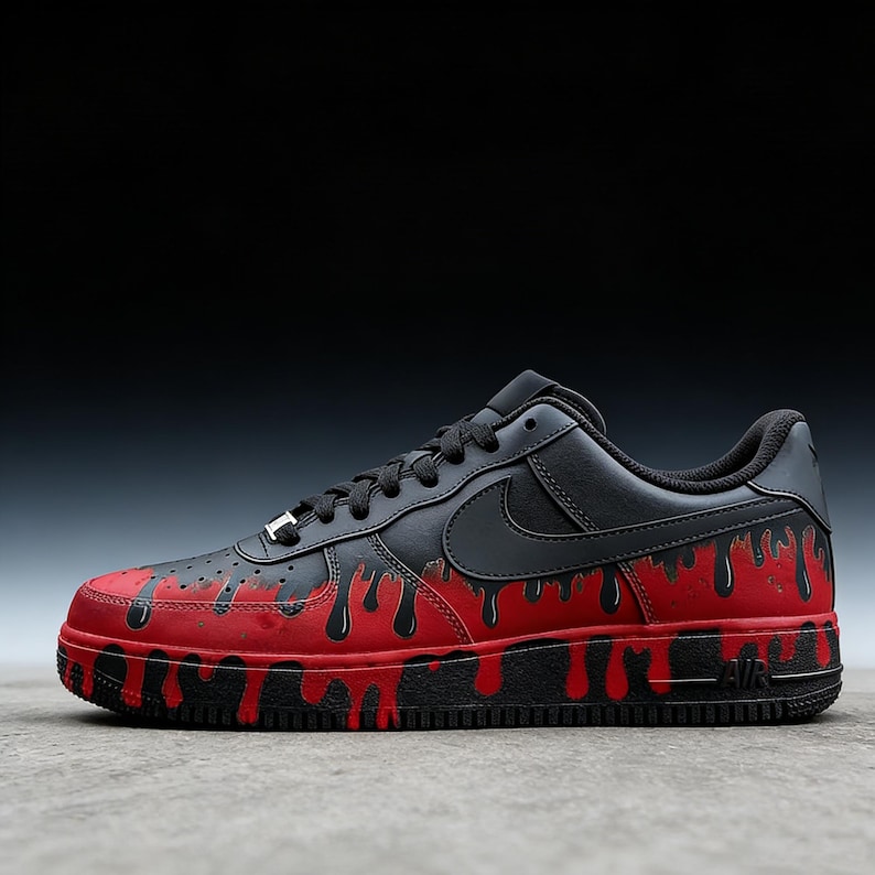 May include: Black and red custom Air Force 1 sneakers. The black leather upper features a black Nike swoosh and laces. The red base has black dripping paint details. The sole is black with "AIR" branding.