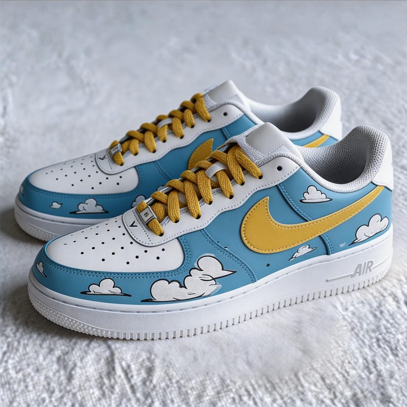 May include: A pair of custom-painted trainers. The shoes have a white base with light blue and white details, a yellow swoosh, and cloud graphics. The laces are yellow, and the soles are white.