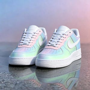 May include: A pair of white and pastel-colored sneakers with a pearlescent finish. The shoes feature a white sole, laces, and swoosh logo. The upper part of the shoe transitions from pink to blue and green.