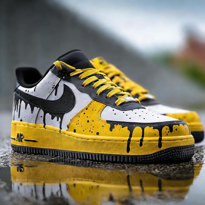 Puede incluir: Zapatillas personalizadas blancas, negras y amarillas con un dise&ntilde;o &uacute;nico de pintura de goteo. Las zapatillas presentan un logotipo Nike negro, cordones amarillos y una suela amarilla. La palabra "AIR" es visible en el lateral de la suela.