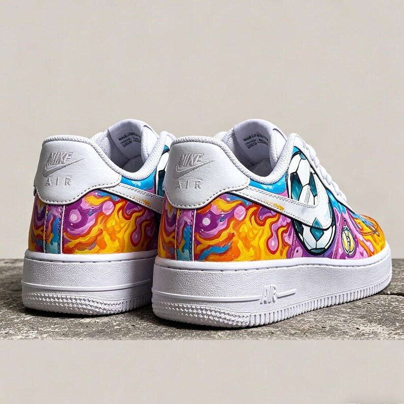 May include: White Nike Air Force 1 sneakers with custom colorful artwork. The design features a soccer ball graphic and a vibrant mix of orange, purple, and blue abstract patterns. The shoes have white soles and the Nike Air logo.