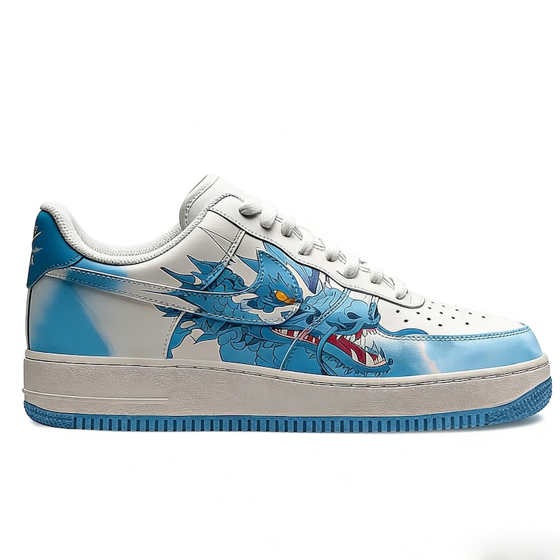 May include: White and light blue sneakers with a dragon design. The low-top shoes feature a white base with blue accents and a detailed illustration of a blue dragon on the side. The sole is light grey with a blue outsole.