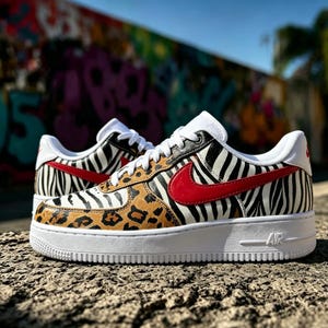 May include: Low-top trainers with a distinctive animal print pattern. The shoes combine zebra stripes, leopard spots, and a red swoosh logo on a white sole. The trainers are set against a graffiti background.