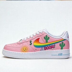 May include: Pink Air Force 1 sneaker with white laces and sole. Features a rainbow swoosh, cactus, sun, and "BOOM!" graphic. Includes a dollar sign and "AIR" text.