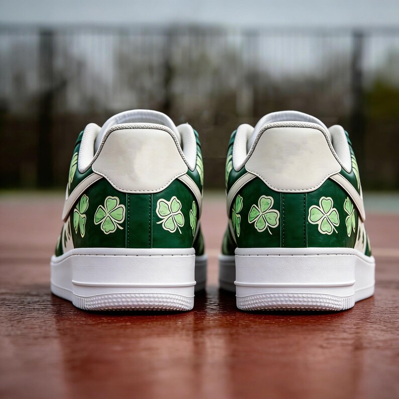 May include: Pair of green and white sneakers with a clover pattern. The shoes have a white sole and a green upper with light green shamrock designs. The back of the shoe is white with a green accent.