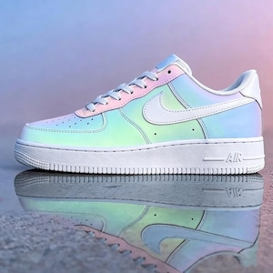 May include: A single iridescent Nike Air Force 1 sneaker. The shoe features a white sole and swoosh, with a pastel color gradient across the upper, transitioning from pink to blue and green. The word "AIR" is visible on the midsole.
