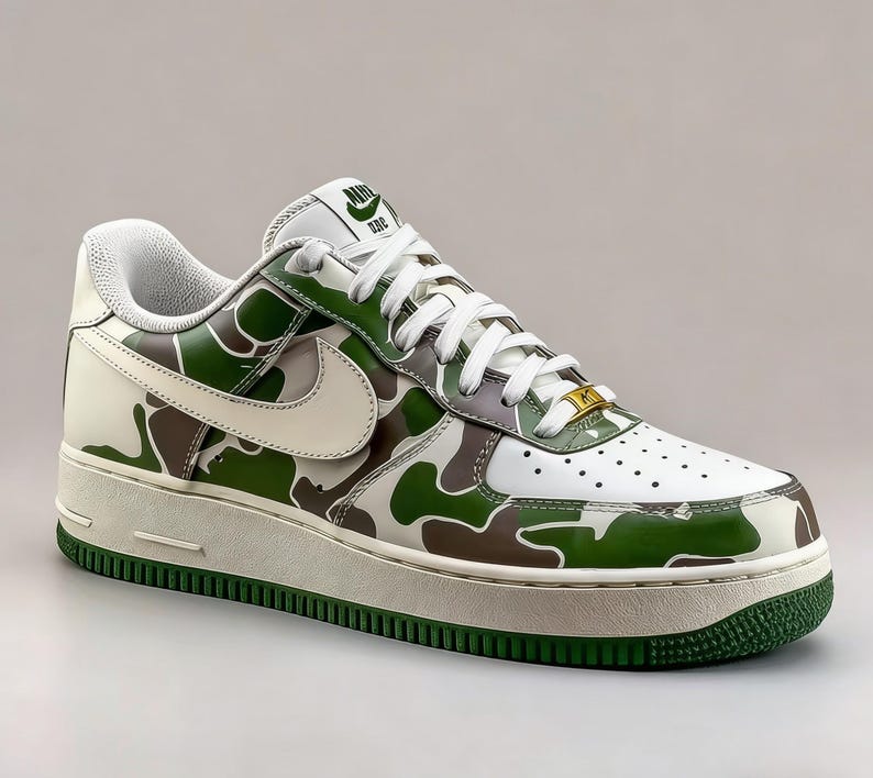 May include: White, green, and brown camouflage Air Force 1 sneakers. The shoe features a white swoosh, laces, and midsole. The outsole and trim are green. The tongue has a green logo. The toe box has small perforations.