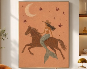 May include: A rectangular wall art print featuring a terracotta-colored background with a crescent moon and stars. The central illustration depicts a figure with a mermaid tail and a cowboy hat riding a brown horse in a galloping motion.