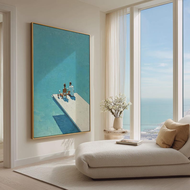 May include: An abstract painting in a gold frame depicts two figures on a white platform against a turquoise background. The artwork, with its minimalist style, evokes a sense of tranquility and leisure. The painting is displayed in a modern living space with a chaise lounge and a view of the ocean.