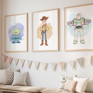 May include: Three framed prints of Toy Story characters hang above a bench with storage cubes. A giraffe toy stands to the left. The prints feature the characters Alien, Woody, and Buzz Lightyear in a child's room.