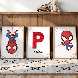 May include: Three framed Spider-Man art prints. One shows Spider-Man upside down, another features the letter "P" with a spiderweb design and the name "Peter", and the third depicts Spider-Man swinging. Each print has a white background.
