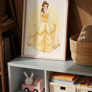 Puede incluir: Una impresi&oacute;n en acuarela enmarcada de una princesa con un vestido amarillo. La obra de arte se exhibe en un mueble azul claro, con un cami&oacute;n de juguete rosa y un juguete de conejito blanco en el estante abierto del mueble. Tambi&eacute;n se ve una cesta tejida y libros.