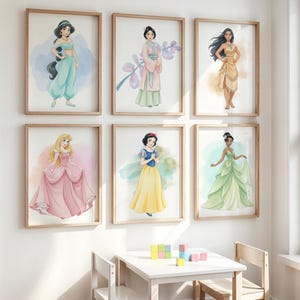 Puede incluir: Seis impresiones enmarcadas de acuarelas de princesas de Disney, incluyendo a Jasm&iacute;n, Mulan, Pocahontas, Aurora, Blancanieves y Tiana. Cada princesa est&aacute; representada de cuerpo entero, vistiendo sus trajes ic&oacute;nicos. Las impresiones se exhiben en una pared blanca.