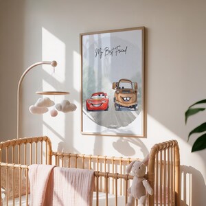 May include: A framed print featuring two cartoon cars, one red and one brown, on a gray road. The text "My Best Friend" is written above the cars. The print is displayed in a nursery setting with a wooden crib and mobile.