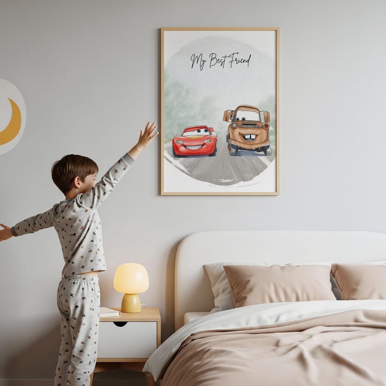 May include: A framed print featuring watercolor illustrations of two cartoon cars, a red race car and a brown tow truck, on a gray road. The text "My Best Friend" is written above the cars. The print is in a light wood frame.