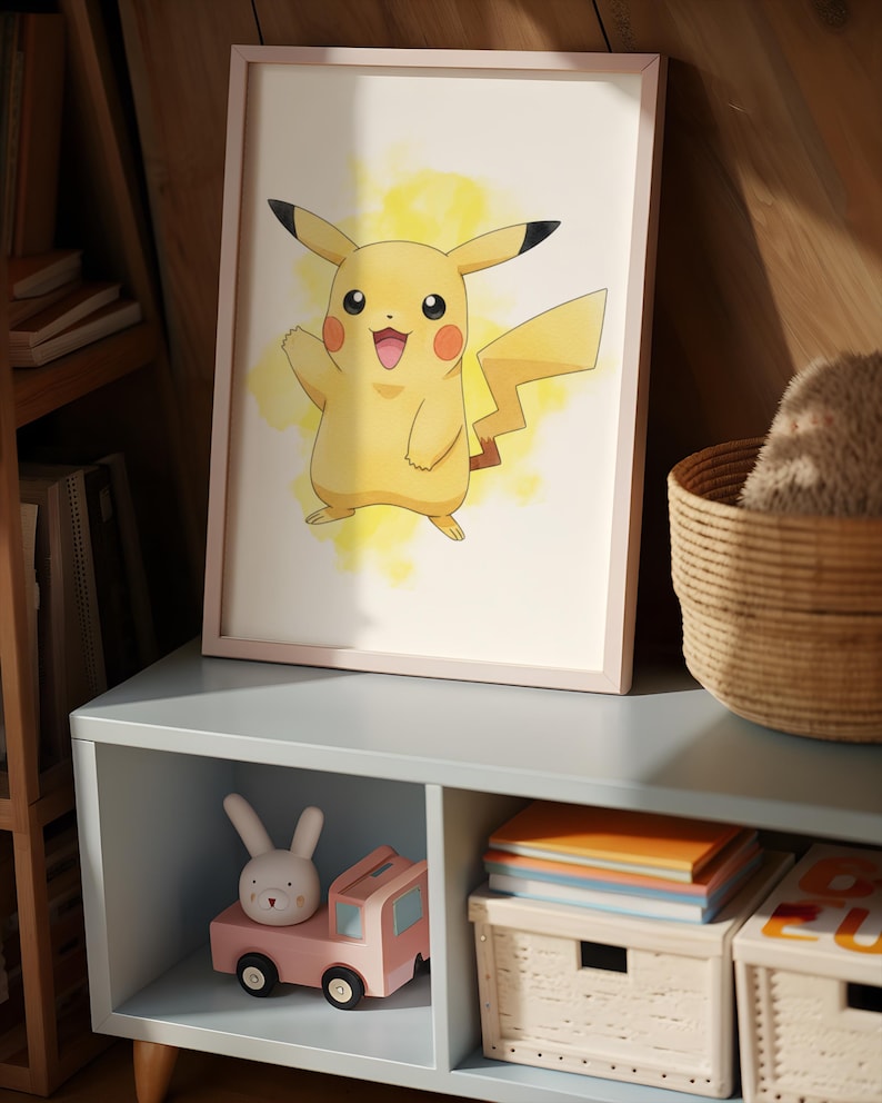 May include: A framed Pikachu art print with a light pink frame. The artwork features a yellow Pikachu character with a yellow watercolor background. A pink toy truck and a white bunny toy are on a blue shelf below the print.