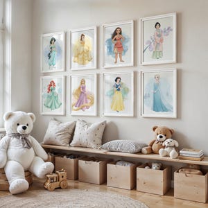 Puede incluir: Una colecci&oacute;n de ocho impresiones en acuarela enmarcadas de princesas de Disney, incluyendo a Jasmine, Bella, Pocahontas y otras, exhibidas en una pared. Un gran oso de peluche blanco se sienta sobre una base de madera, con un banco de madera debajo que contiene cajas de almacenamiento y peluches.