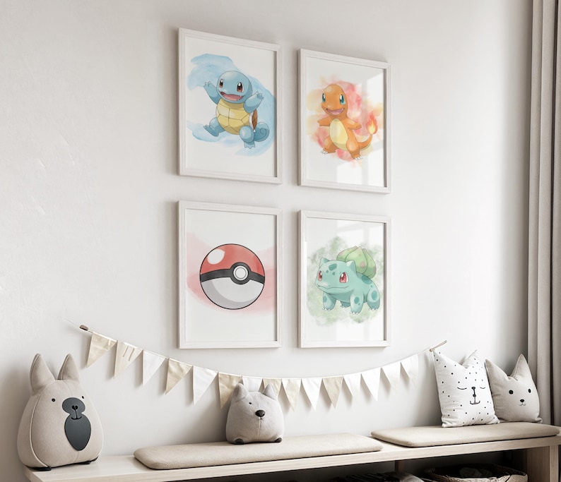 May include: Four framed watercolor prints featuring Pok&eacute;mon characters: Squirtle, Charmander, Bulbasaur, and a Pok&eacute; Ball. The prints are in white frames and are displayed on a white wall. A decorative banner and stuffed animal pillows are below the prints.