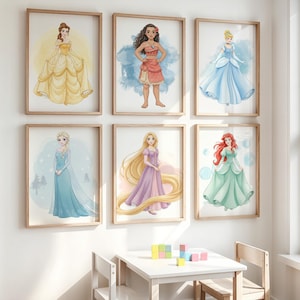 Puede incluir: Seis impresiones en acuarela enmarcadas de princesas de Disney. Las princesas son Bella con un vestido amarillo, Moana con un atuendo rojo, Cenicienta con un vestido azul, Elsa con un vestido azul, Rapunzel con un vestido morado y Ariel con un vestido verde.
