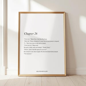 May include: A framed print with a gold-colored frame. The print features the text "Chapter 26" at the top, followed by a passage of dialogue. The words "HEATED RIVALRY" are at the bottom of the print.