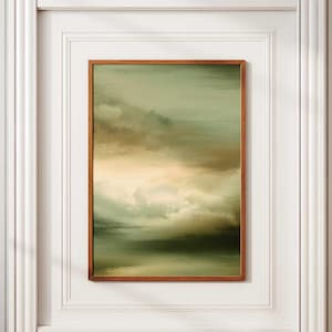 Peut inclure: Impression d'art de paysage abstrait dans un cadre en bois. L'œuvre présente un mélange de teintes vertes, brunes et jaunes, créant un effet nuageux ou atmosphérique. L'art encadré est exposé contre un mur blanc avec des moulures décoratives.